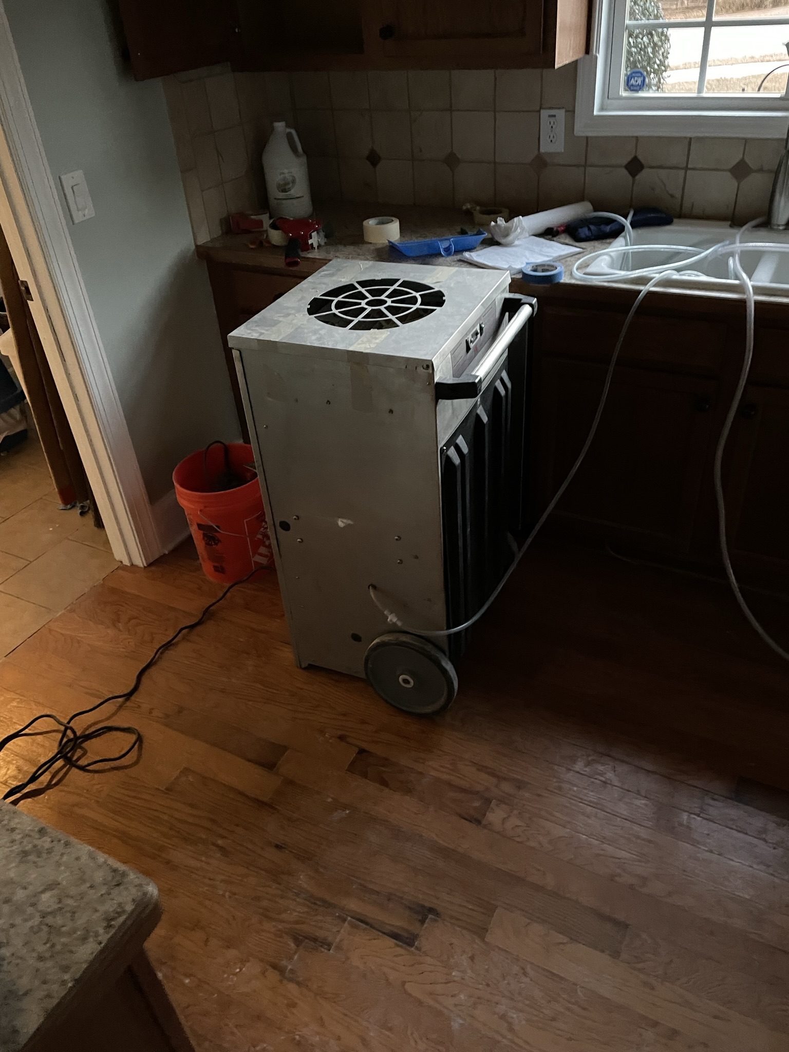 Portable dehumidifier drying out a room after a water damage job